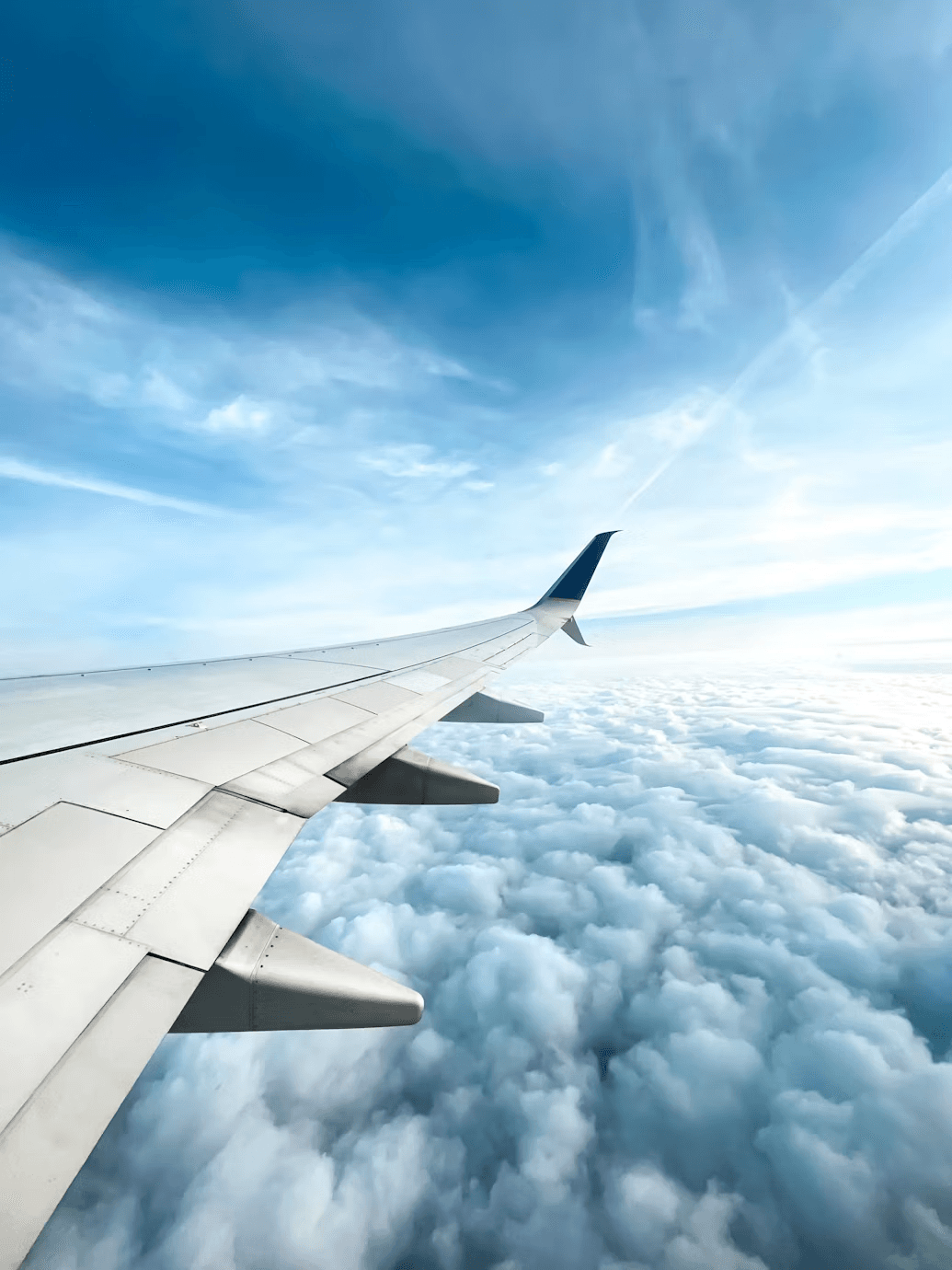 Airplane wing above clouds on a flight to Kashmir